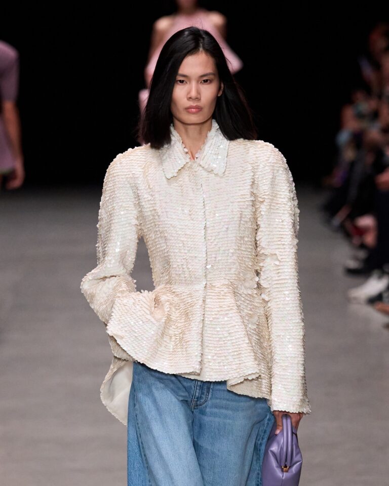 Model wearing a cream tweed peplum jacket with jeans, styled. Stella McCartney